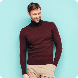 Man wearing a maroon turtleneck sweater and beige pants stands against a light blue background with rounded corners. His posture is relaxed with one hand in his pocket, creating a casual and confident mood. No visible text in the image.